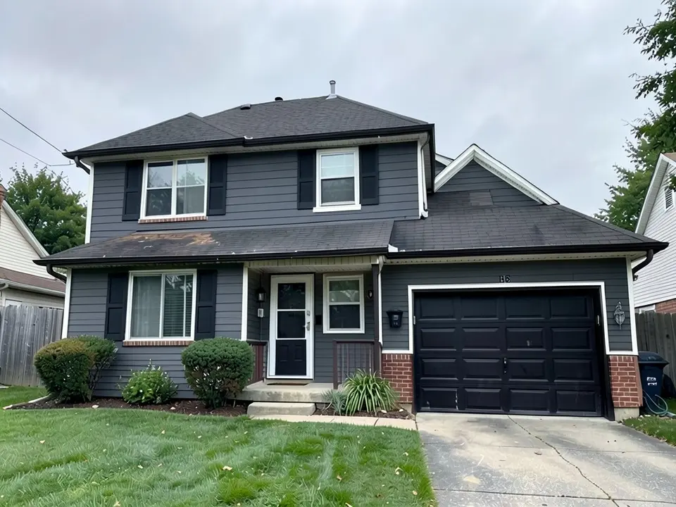 The same house with charcoal gray siding, white trim, black shutters, a black garage door and a darker roof
