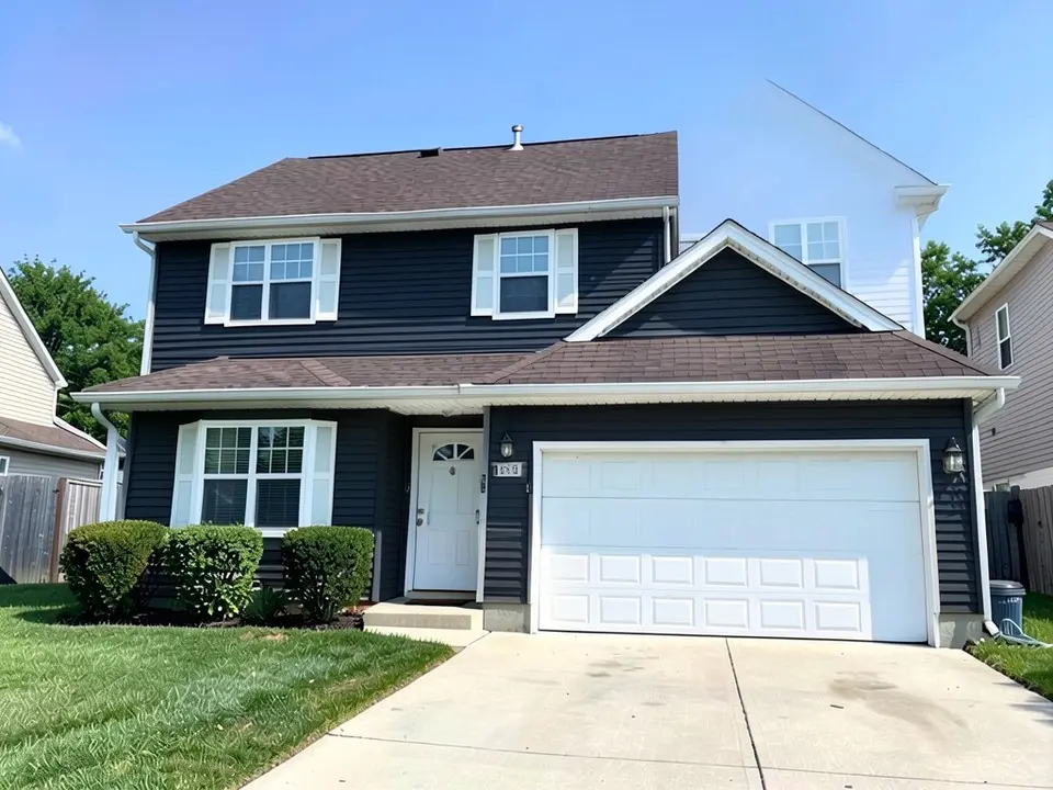 The same house with deep charcoal siding; white trim, doors and brown roof kept