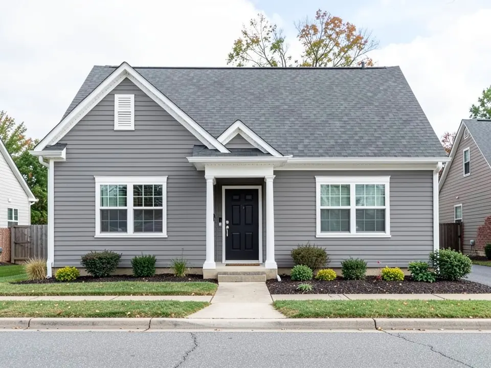 AI-drawn generic stand-in of a suburban house with mid-gray lap siding, white trim, a black front door and a gray roof