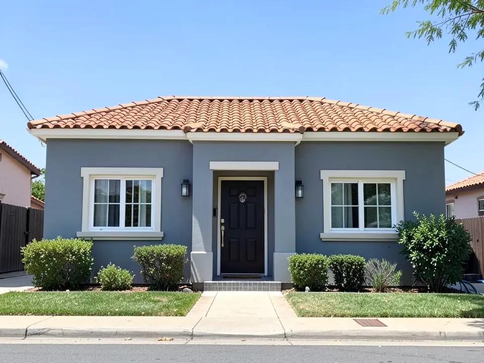 AI-drawn generic stand-in of a one-story Mediterranean-style house with cool gray stucco walls, white window trim, a black front door and an orange clay tile roof