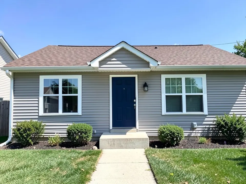 AI-drawn generic stand-in of a one-story ranch house with light gray siding, a brown shingle roof with a small gable above the navy front door, two white windows and a concrete step