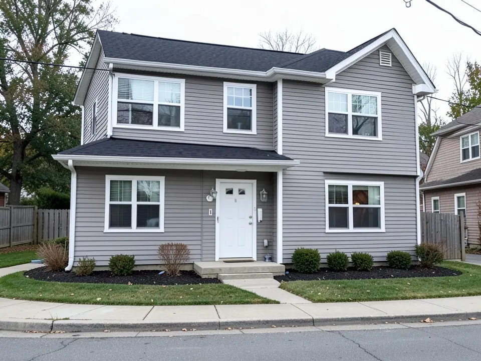 AI-drawn generic stand-in of a two-story house with medium gray lap siding, white trim, a black roof and a white front door
